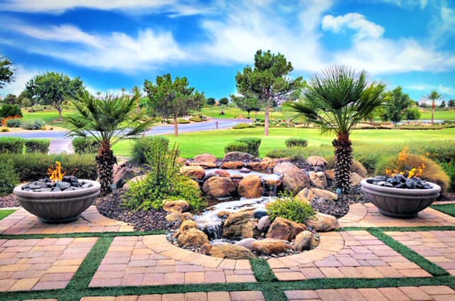 A pondless waterfall in a backyard surrounded by rocks