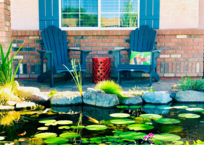 A pond with lilypads and several chairs